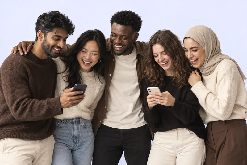 Friends laughing together over their phones